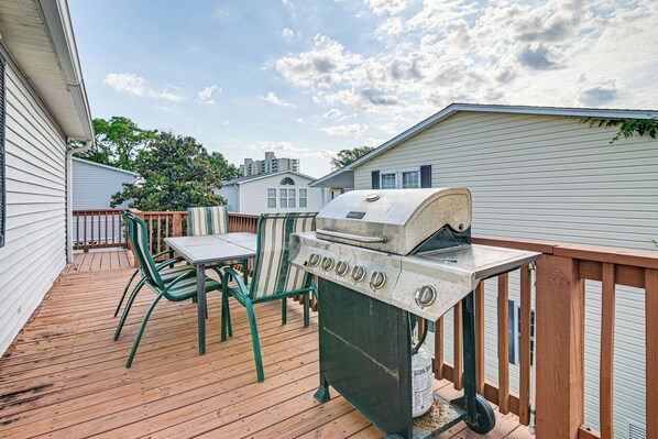 A wooden deck with a grill and chairs, surrounded by white houses. - Walk to Surfside Beach: Home w/ Pool Access (Murrells Inlet)