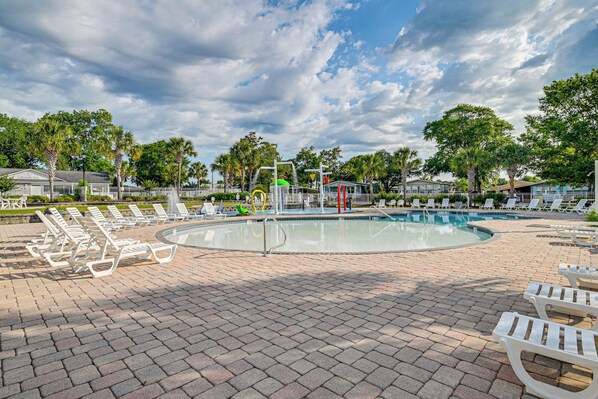 A pool area with lounge chairs and a circular pool. - Walk to Surfside Beach: Home w/ Pool Access (Murrells Inlet)