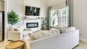 A modern living room with a sofa, TV, and a bookshelf. - Walk to Boat Ramp: Lake Greenwood Getaway! (Greenwood)