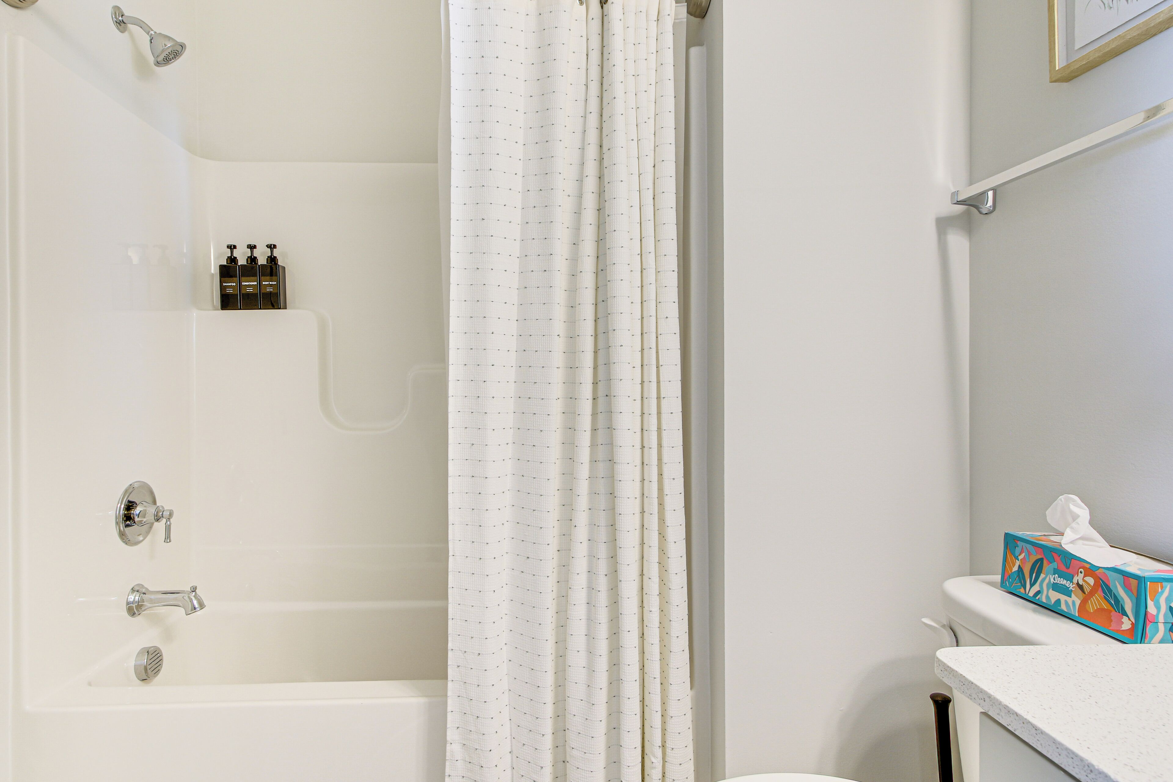 A bathroom with a bathtub, shower, and toilet.