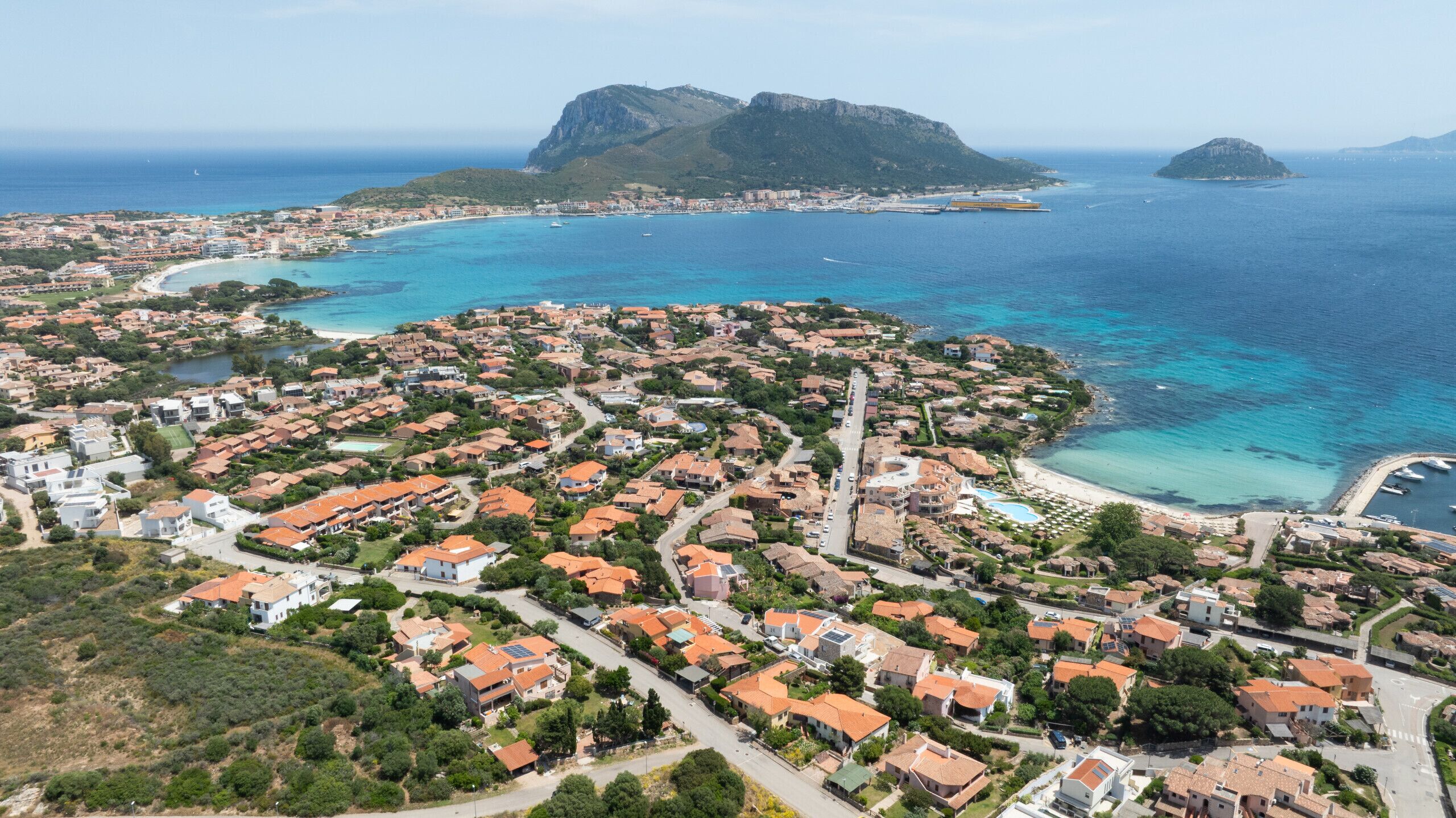 An aerial view of a coastal town with a mix of residential buildings and a prominent church.