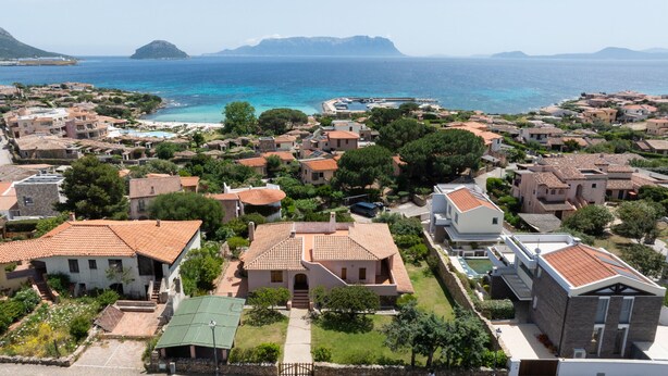 A coastal town with traditional Mediterranean architecture, including terracotta-tiled roofs and stone buildings.