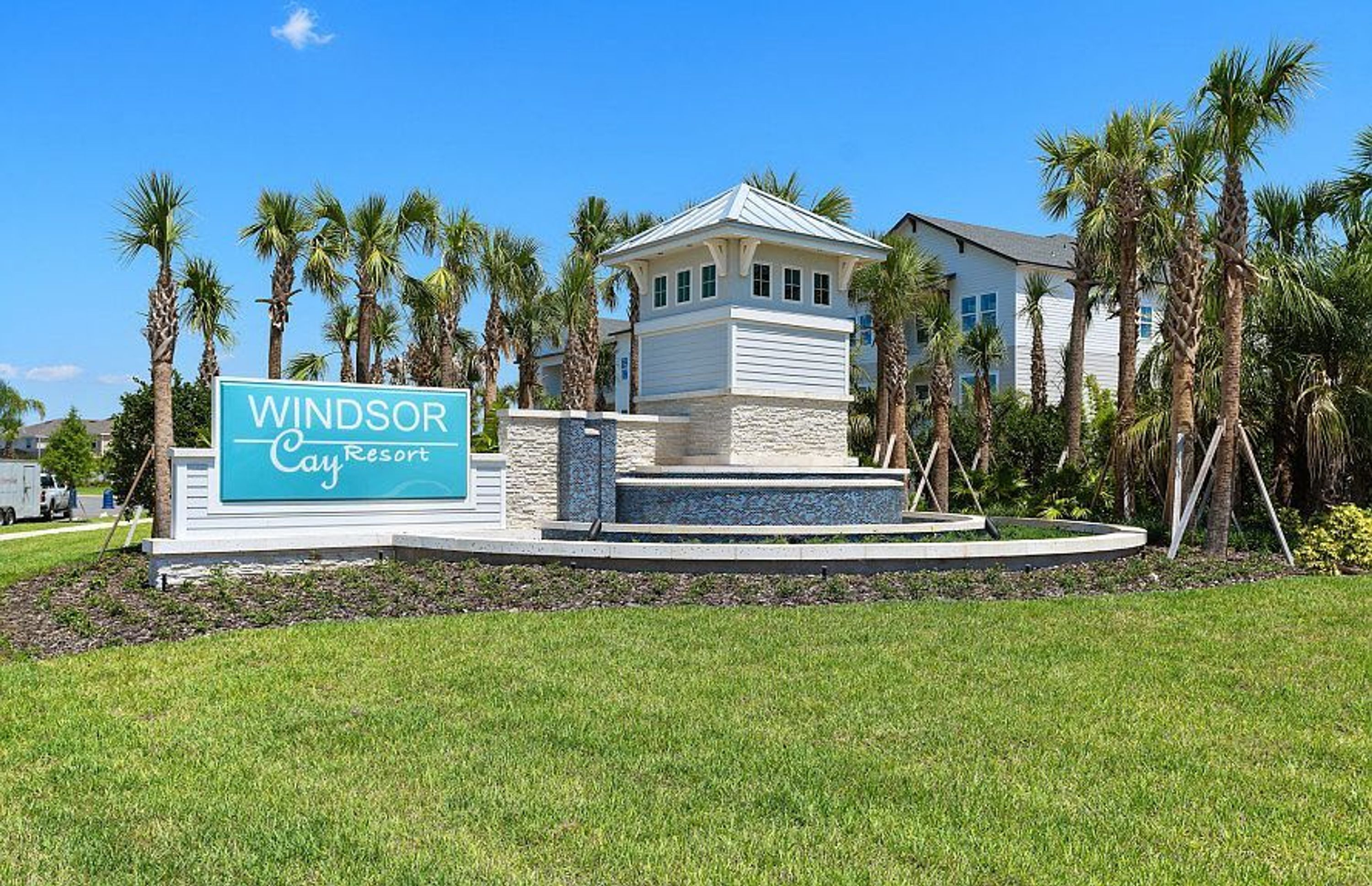 Naamplaatje voor Windsor Cay Resort, met een zwembad en palmbomen.