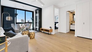 Una sala moderna con sofá, una mesa de centro y un comedor con sillas.