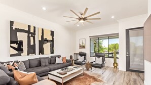 A modern living room with a sectional sofa, a coffee table, and a large abstract painting. - NEW Desert Standard Modern 3-level Oasis (Scottsdale)