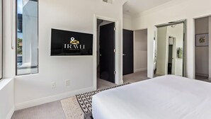 A modern hotel room with a large bed, a mounted TV, and a view of the outside. - NEW Desert Standard Modern 3-level Oasis (Scottsdale)