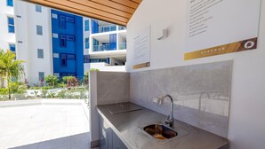 A modern kitchen with a stainless steel sink and a built-in oven. - 3BR Lux Beachfront Escape - Pool Gym King bed (Sunshine Coast)