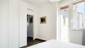 A bedroom with a bed, a door leading to another room, and a window. - Tina's Penthouse by Wonderful Italy (Bari)