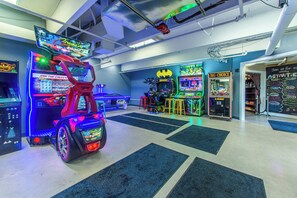 Une salle d’arcade lumineuse, dotée de différents jeux, notamment des jeux de course et des jeux d’action.