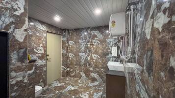 Un baño con paredes de mármol y un lavabo.