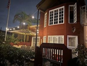 A two-story building with a red exterior, white windows, and a number '717' on the side. - 30 secs to Beach, Ocean-view patio, Roof Deck (San Diego)