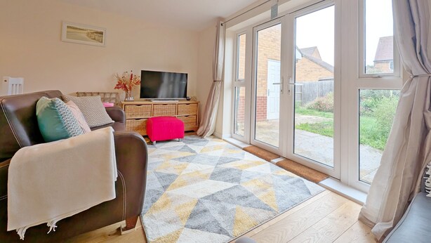 A living room with a sofa, TV, and a large window.