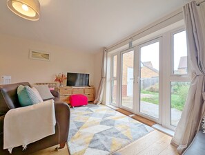 A living room with a sofa, TV, and a large window.