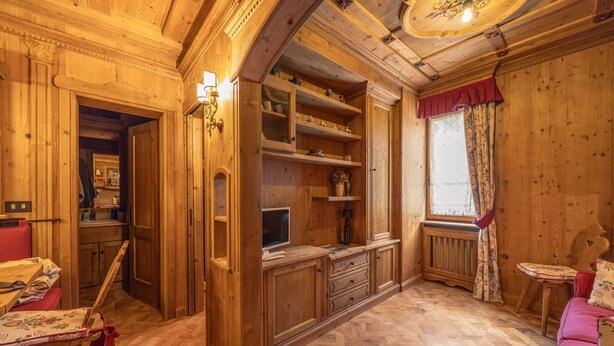 Un intérieur en bois comprenant un coin repas, une cuisine et une fenêtre avec des rideaux.