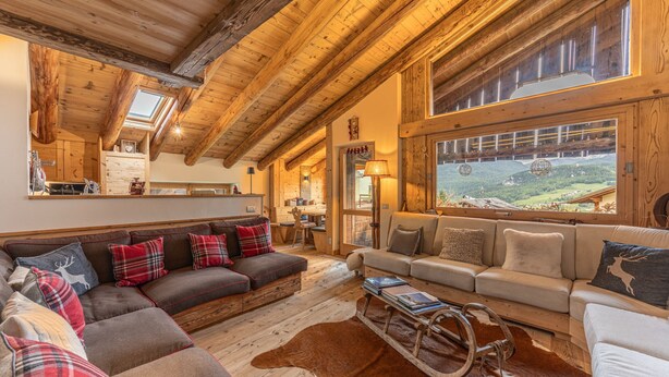 A cozy, wooden-floored living room with two sofas, a coffee table, and a cowhide rug. - Casa Verocip, a panoramic attic with a view of the Dolomites (Cortina d´Ampezzo)