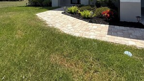A modern two-story house with a paved driveway and a well-maintained lawn.