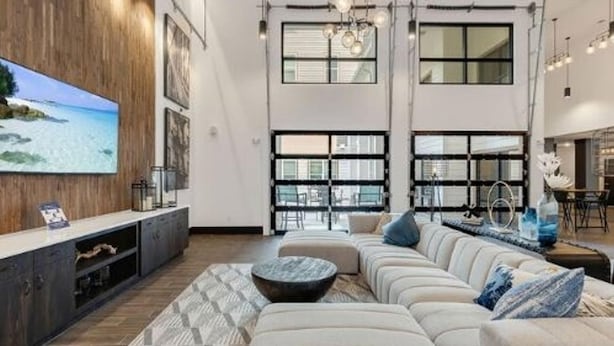 A spacious living area with a large flat-screen TV, a sectional sofa, and a coffee table. - Landing | Incredible 1BD, Pool, Clubhouse (Jacksonville)