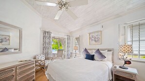 A bedroom with a large bed, a nightstand, a dresser, and a window with curtains. - Waverly One 3 Bedroom Townhouse (Gibbes)