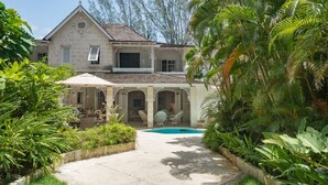 A two-story house with a swimming pool, surrounded by lush greenery and a covered patio area. - Waverly House 3 Bedroom Townhouse (Bowling Alley Hill)