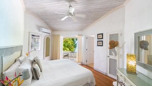 A bedroom with a bed, a ceiling fan, a desk with a mirror, and a view of the outdoors. - Waverly House 3 Bedroom Townhouse (Bowling Alley Hill)