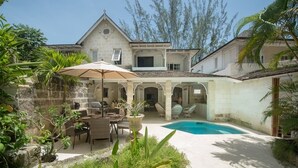 A stone building with a pool, outdoor seating, and tropical plants. - Waverly House 3 Bedroom Townhouse (Bowling Alley Hill)