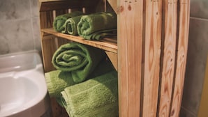 A wooden shelf with green towels in a bathroom. - Apartment With Mountain View (Treffen)