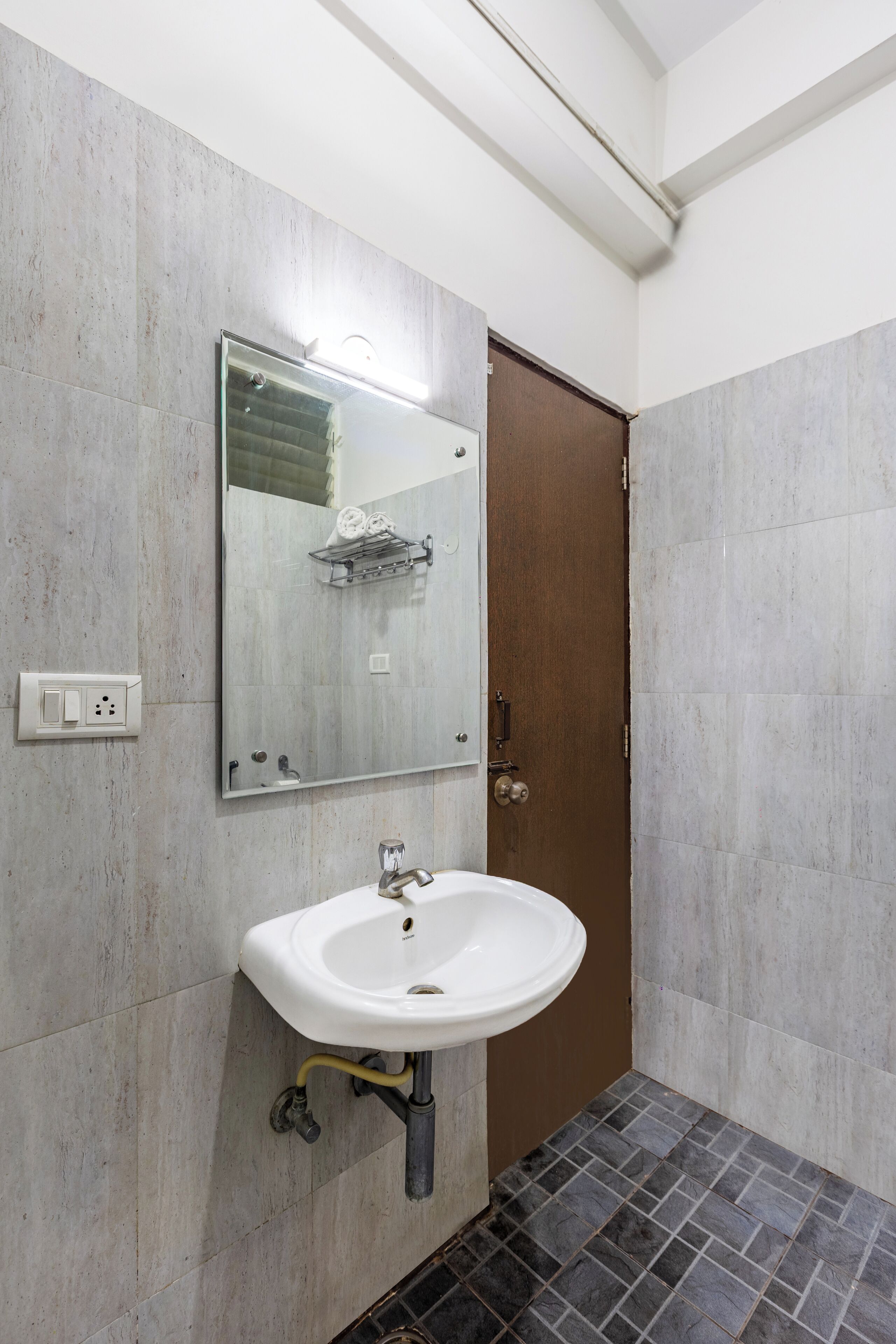 A bathroom with a white sink, a mirror, and a shower.
