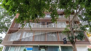 A multi-story hotel with a modern facade, featuring horizontal wooden slats and large windows. - Hotel Acacia Yelahanka (Bengaluru)