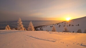 Paisagem coberta de neve com um pôr do sol ao fundo.
