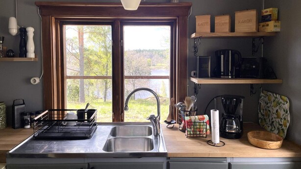A kitchen with a large window, a sink, a stove, and various kitchen appliances. - 7 Person Holiday Home in Bjornlunda (Björnlunda)