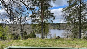 A view of a lake surrounded by trees and a wooden fence. - 7 Person Holiday Home in Bjornlunda (Björnlunda)