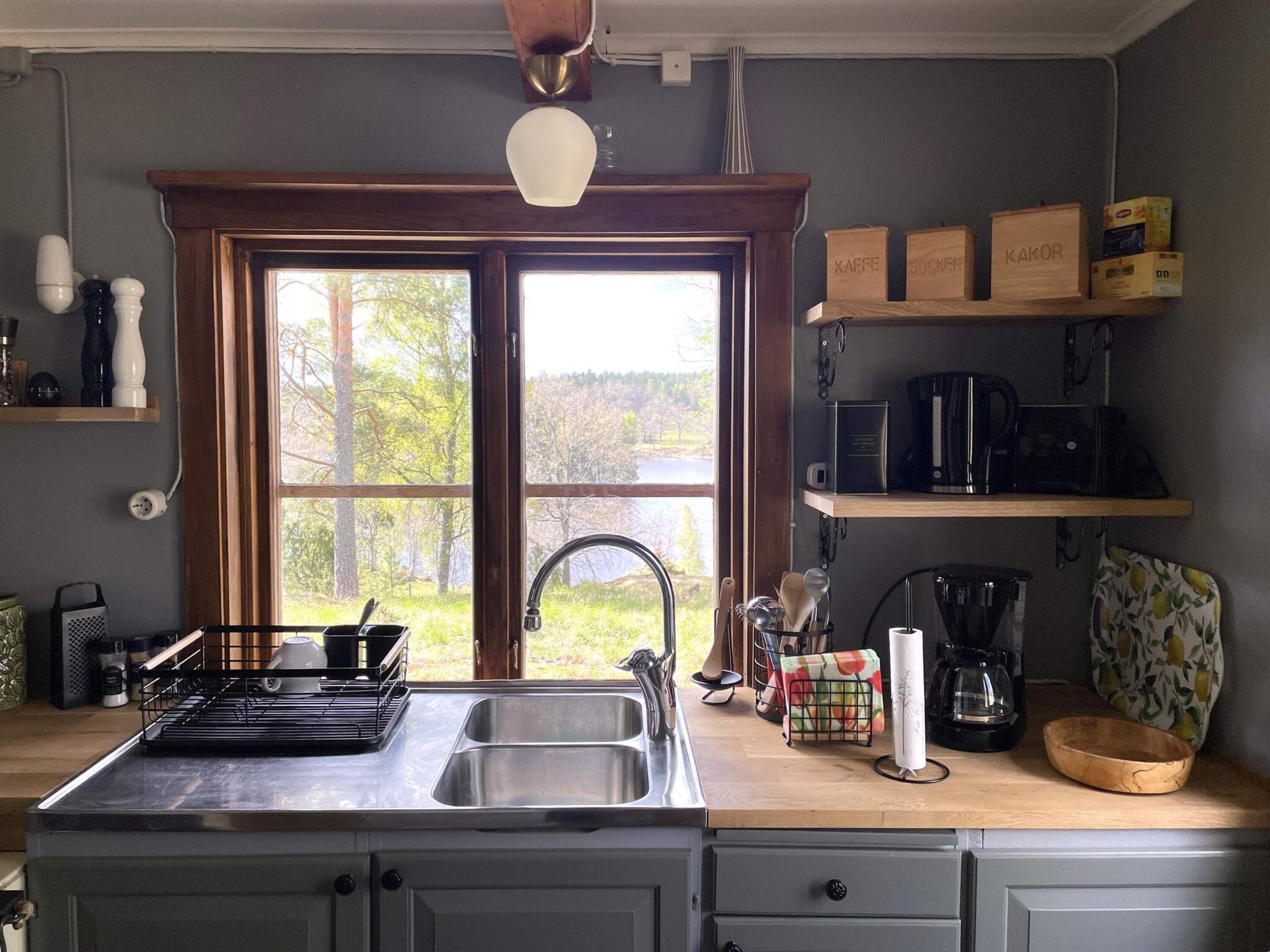 A kitchen with a large window, a sink, and various appliances.