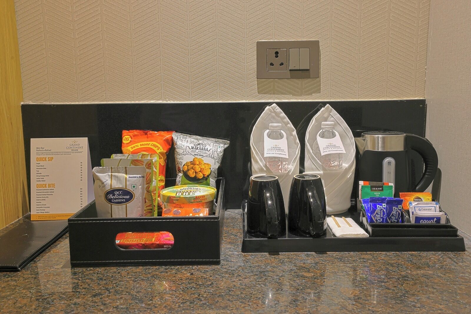 A hotel reception area with a counter displaying snacks, beverages, and a coffee maker.