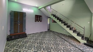 A spacious interior with a tiled floor, a staircase, and a door with a window.