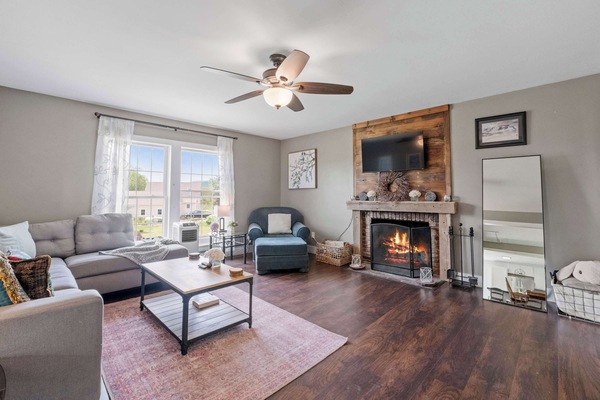Gather 'round the fire after a day of lake funβthis warm and inviting living room offers plush seating, a smart TV, and that perfect touch of rustic charm with its wooden mantel and glowing hearth.