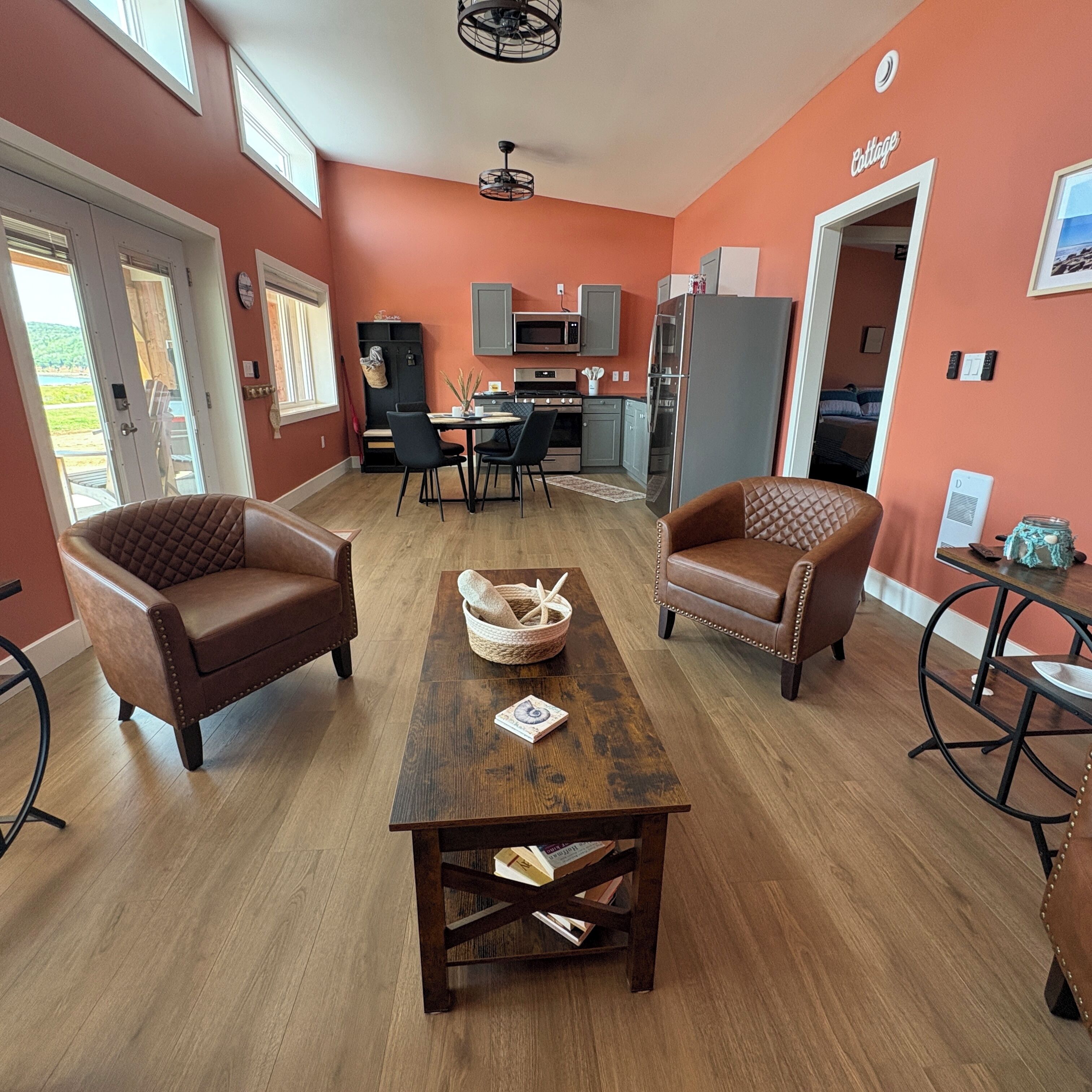 A modern living room with a dining area, a kitchen, and a bedroom.