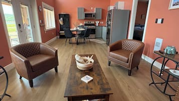 A modern living room with a dining area, a kitchen, and a bedroom.