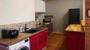 A compact kitchen with a washing machine, a microwave, and a sink.