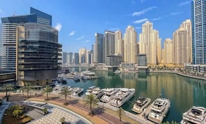 A marina with boats, a modern city skyline, and high-rise buildings.