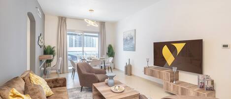 Departamento de lujo, balcón, vista a la ciudad | Área de sala de estar | Smart TV de 65 pulgadas con canales por cable