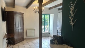 Une pièce spacieuse dotée d’une grande armoire, d’un banc rembourré, d’un lustre et offrant une vue sur l’extérieur.
