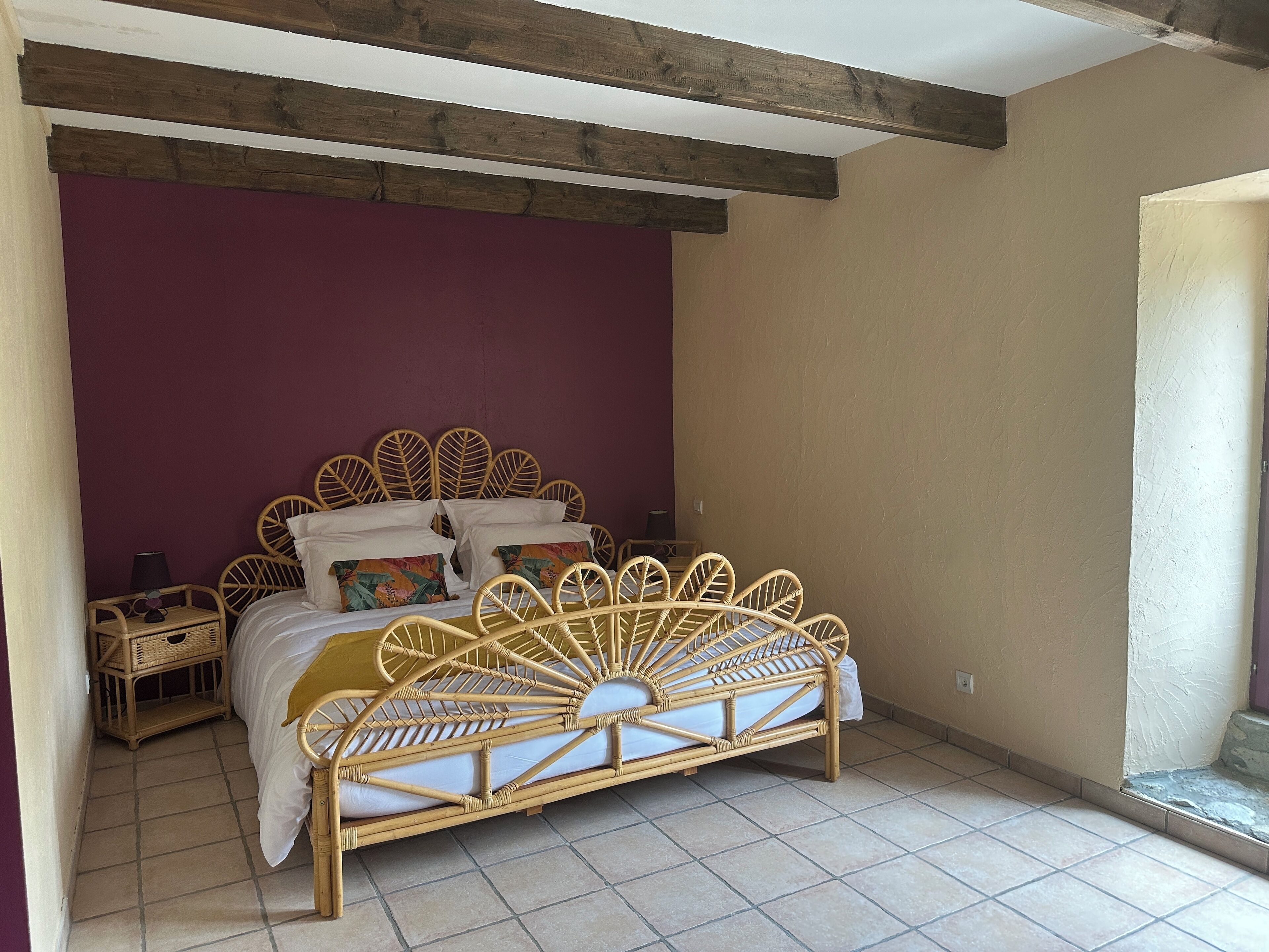 A room with a bed, a nightstand, and a window.