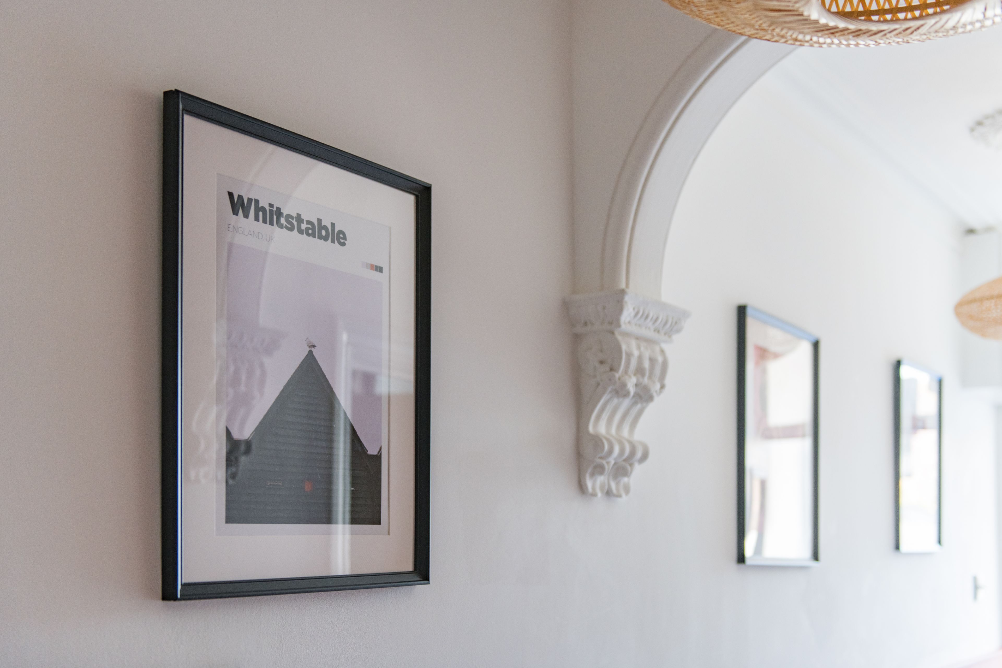 A framed picture of a building with the text "Whitstable" on a white wall.