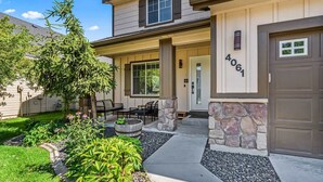 A residential house with a stone facade, a front porch with seating, and a well-maintained garden. - 5 Bedroom house in prime location by the village (Meridian)