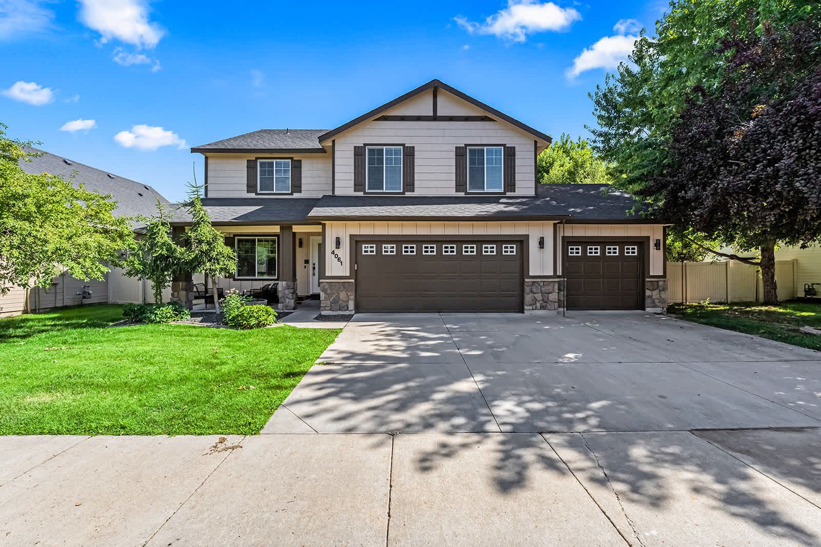A two-story house with a garage, a front lawn, and a driveway.