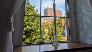 A window with a view of a building and trees.