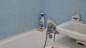 Une salle de bain avec une baignoire, un lavabo et un meuble de rangement.