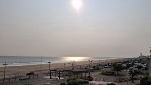 Une vue sur la plage, avec une route et des bâtiments au premier plan.