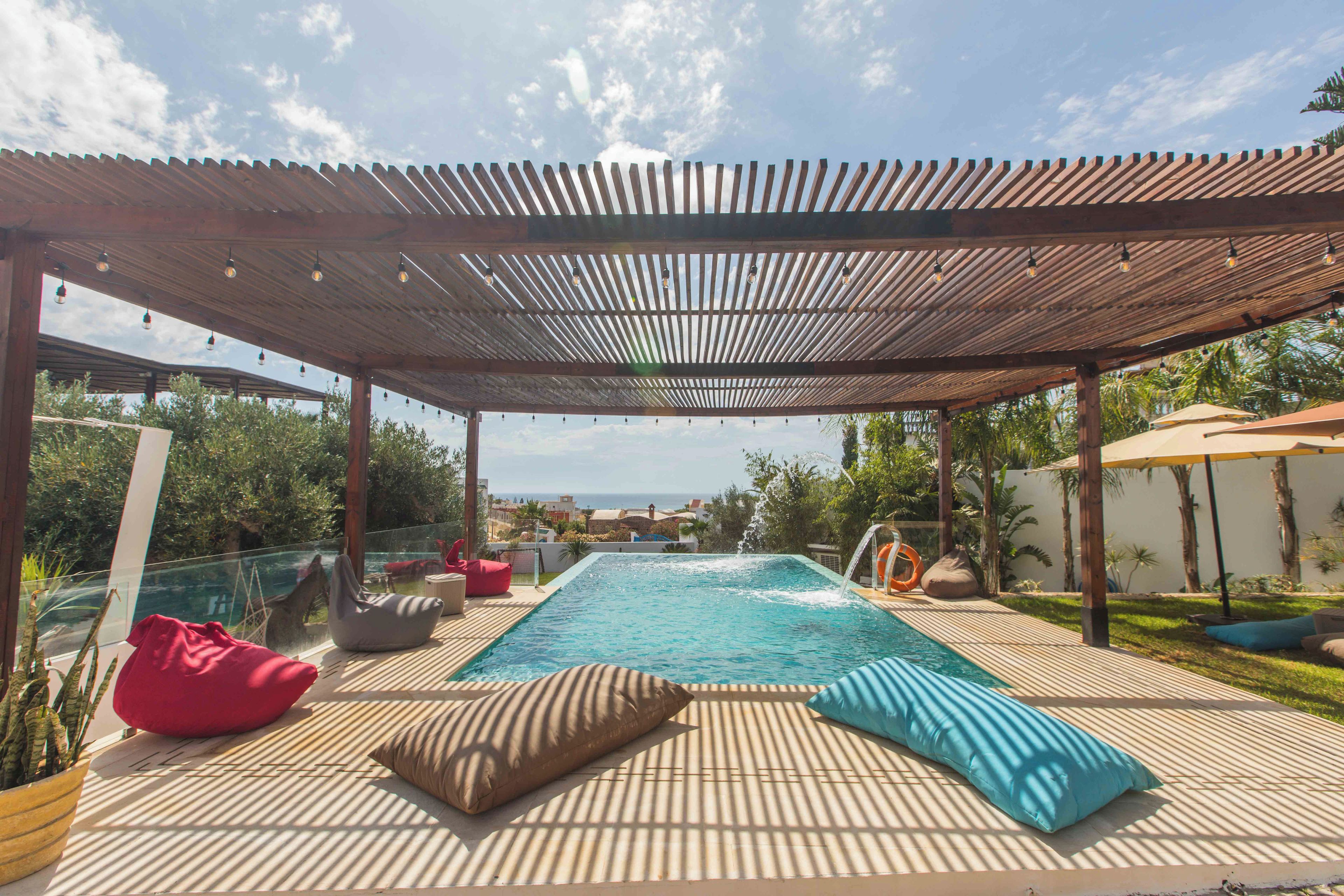 Una piscina coperta all'aperto con lettini prendisole e vista sul mare.