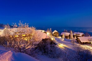 A snow-covered village with wooden houses and a clear night sky. - Apartment by Lake Ossiach With Mountain Views (Treffen)